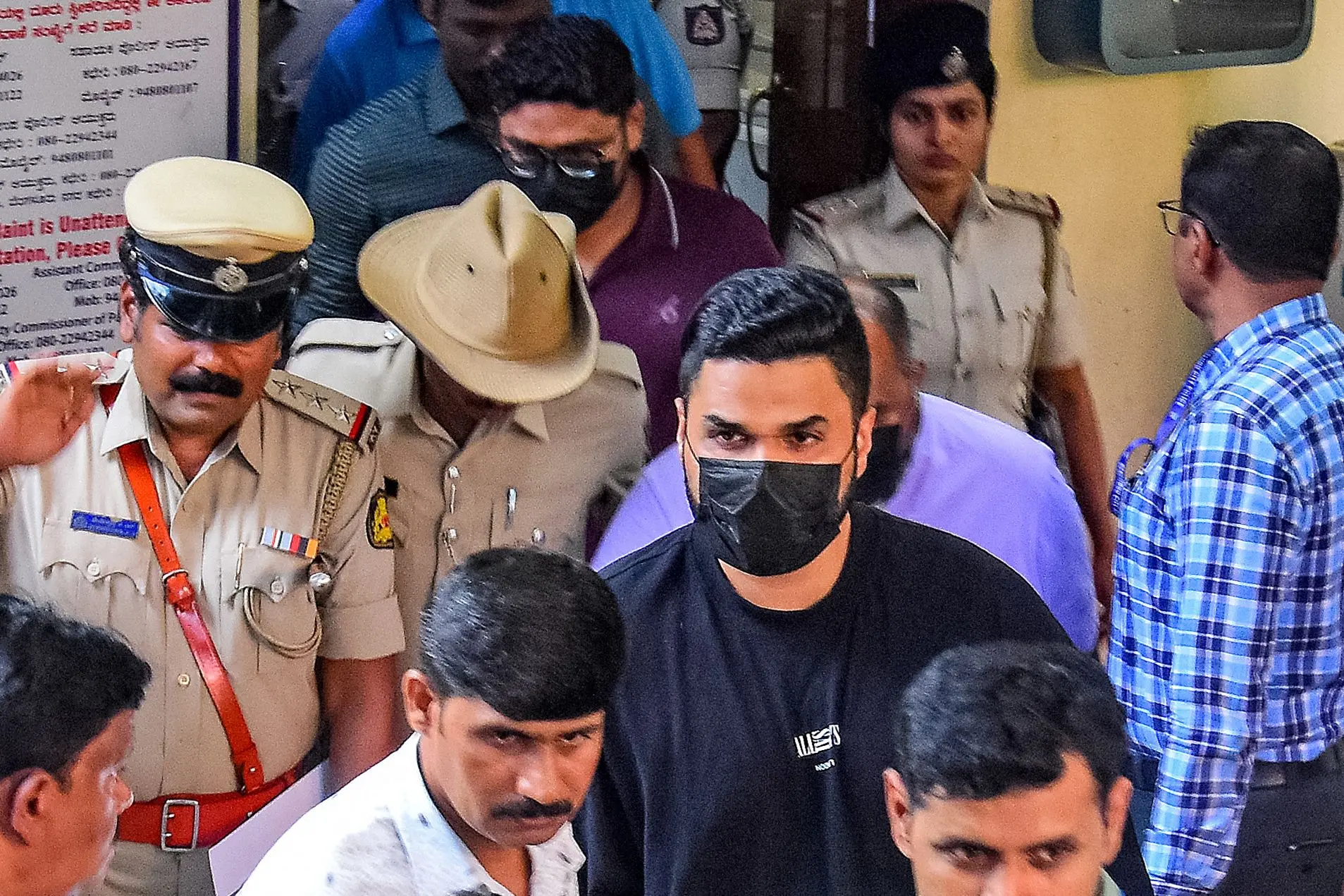 Royal Challengers Bengaluru's (RCB) Head of Marketing and Revenue, Nikhil Sosale (black t-shirt), along with three staff members of DNA Entertainment Networks Private Ltd., being taken to court after their arrest in a stampede incident near the M. Chinnaswamy Stadium, at Cubbon Park Police Station in Bengaluru. | Photo: AFP