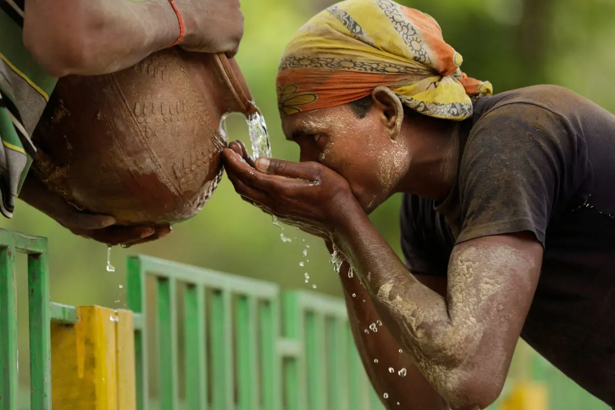 An Indian laborer takes a break to drink water from an earthen pitcher in a hot afternoon in Allahabad (Photo: AP)