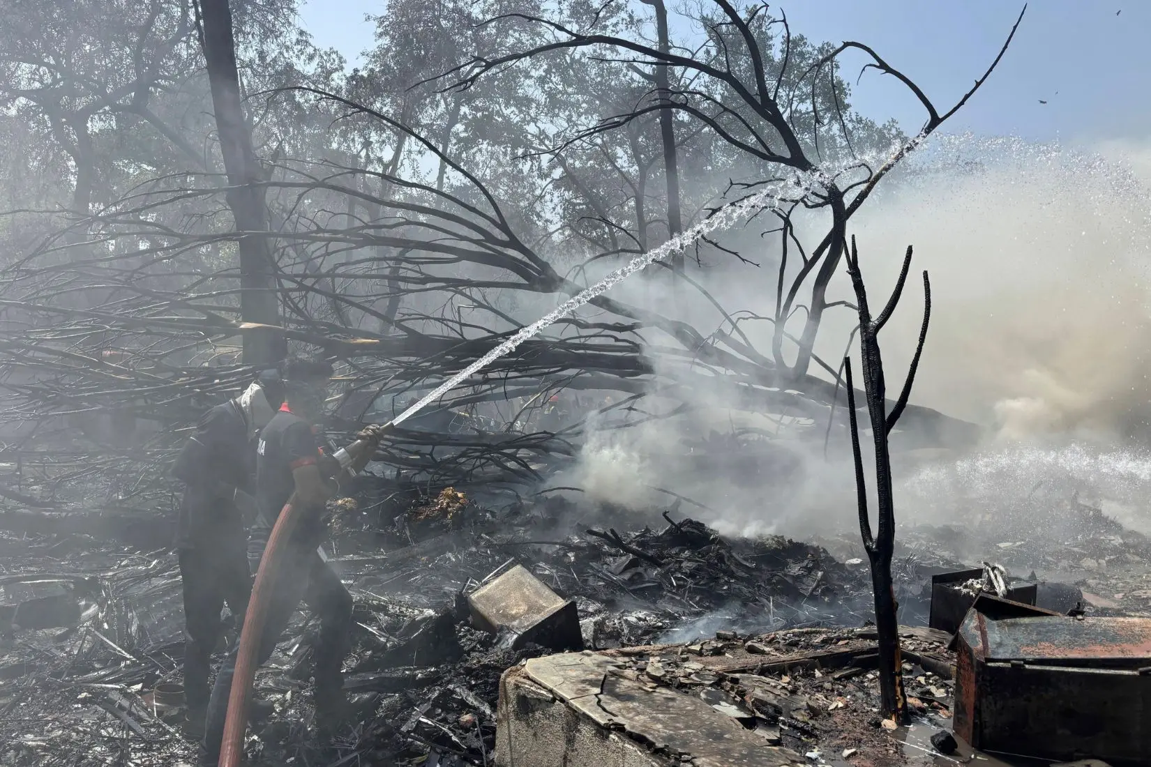 Firefighters work at the site of an airplane that crashed in India's northwestern city of Ahmedabad in Gujarat state, Thursday, June12, 2025.