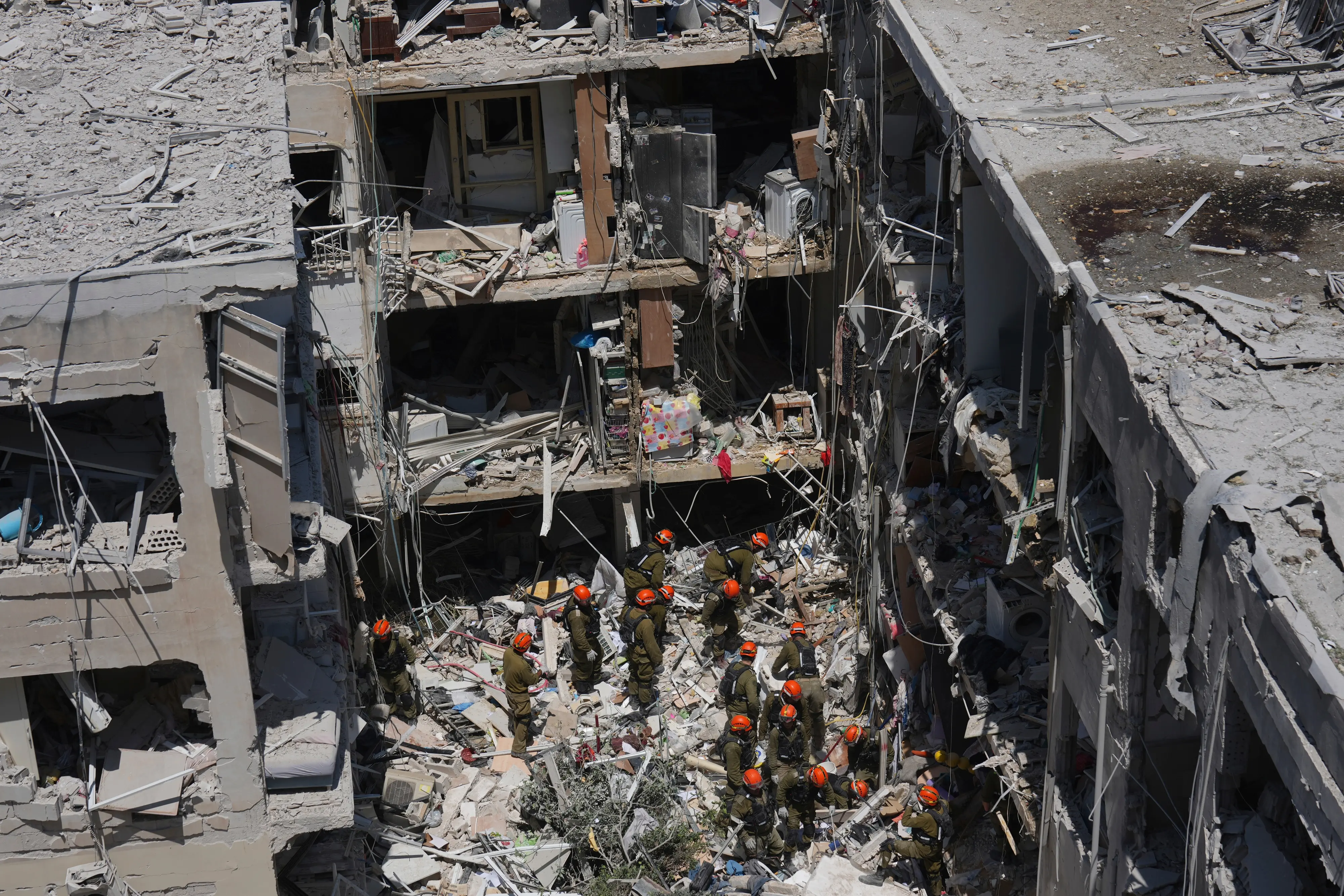 Israeli soldiers dig through rubble to search for survivors in a residential area hit by a missile fired from Iran, in Bat Yam, central Israel. | Photo: AP