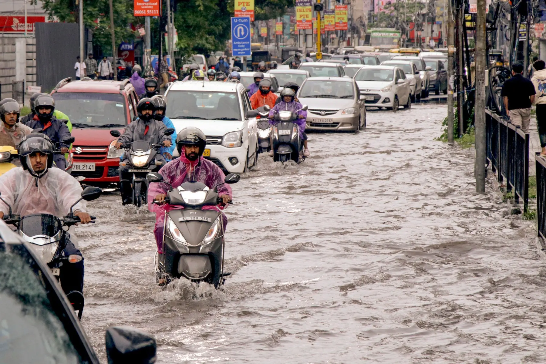 Commuters move through a waterlogged road after heavy rainfall in Kochi | Photo: PTI