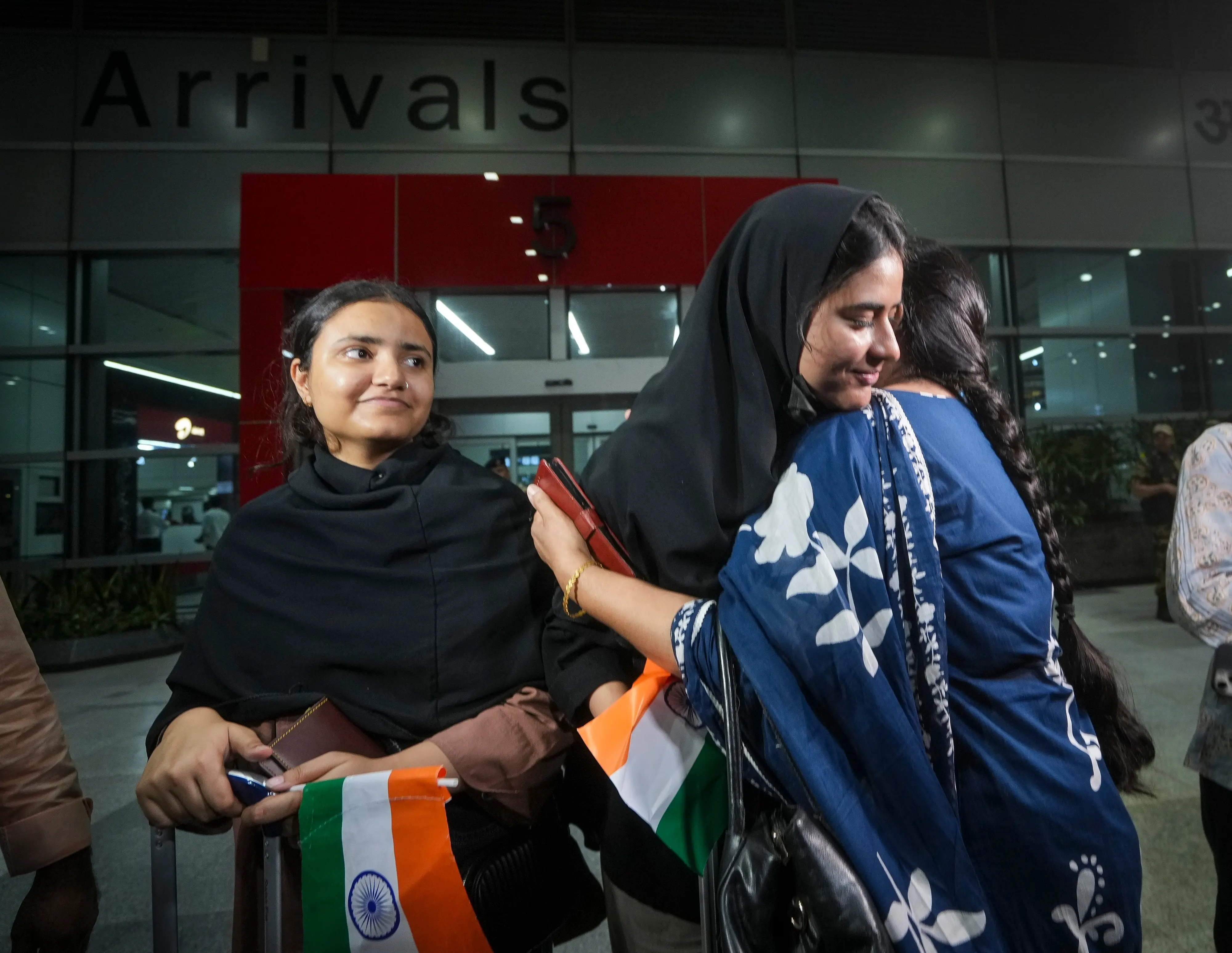 Indian students returning from Iran via Armenia, under an evacuation operation facilitated by the Government of India, react as they meet their relatives while exiting from the Indira Gandhi International Airport, in New Delhi. | Photo: PTI