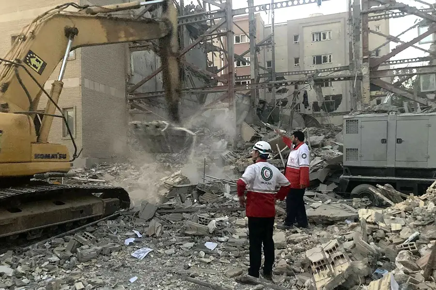 Iranian Red Crescent members clearing debris at a building destroyed during an Israeli attack | AFP
