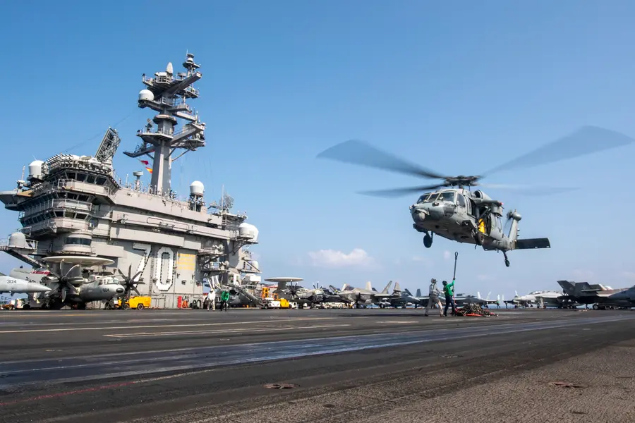A MH-60S Sea Hawk helicopter hovering over the USS Carl Vinson aircraft carrier while operating in the Middle East