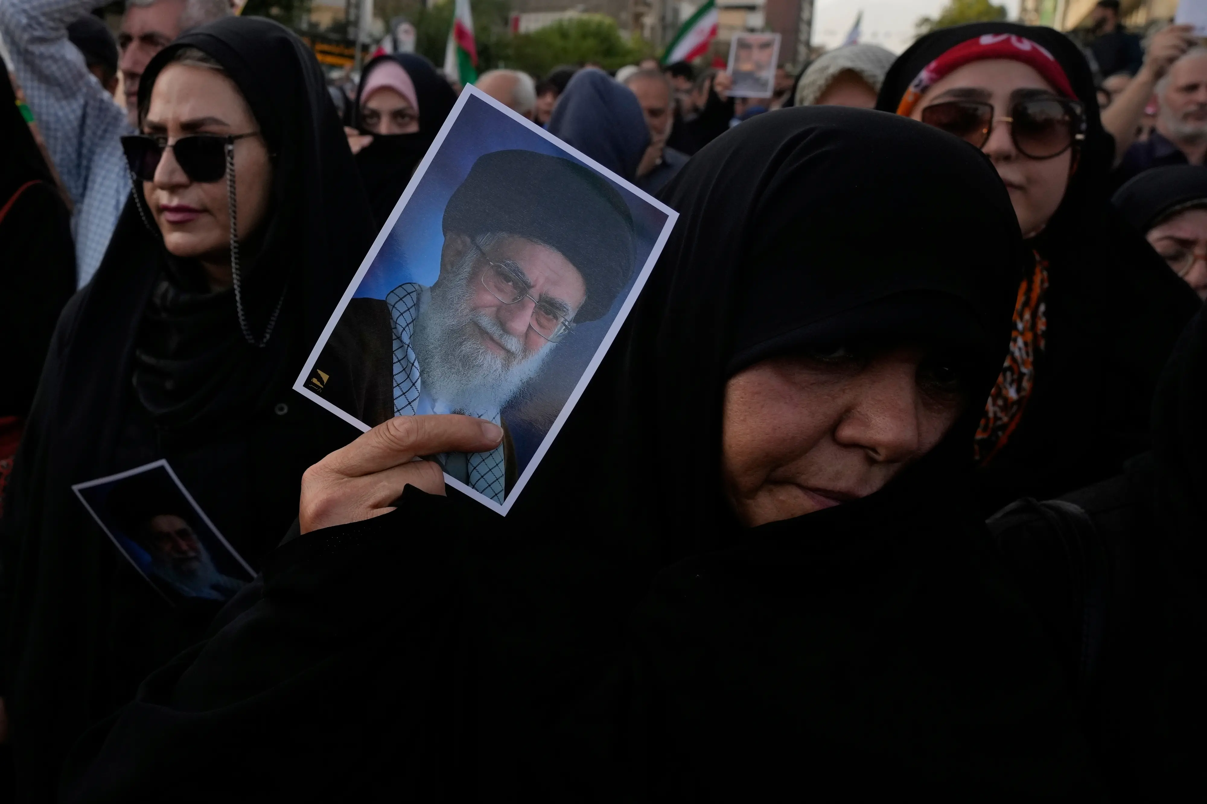 A protester holds up a poster of the Iranian Supreme Leader Ayatollah Ali Khamenei.| Photo: AFP