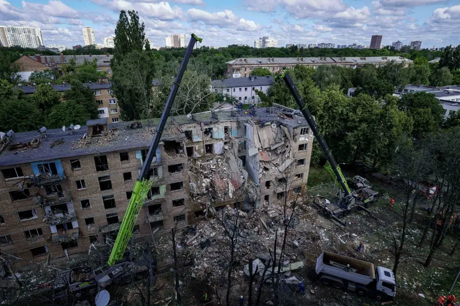 Rescue workers clear the rubble of a residential building destroyed by a Russian strike in Kyiv, Ukraine