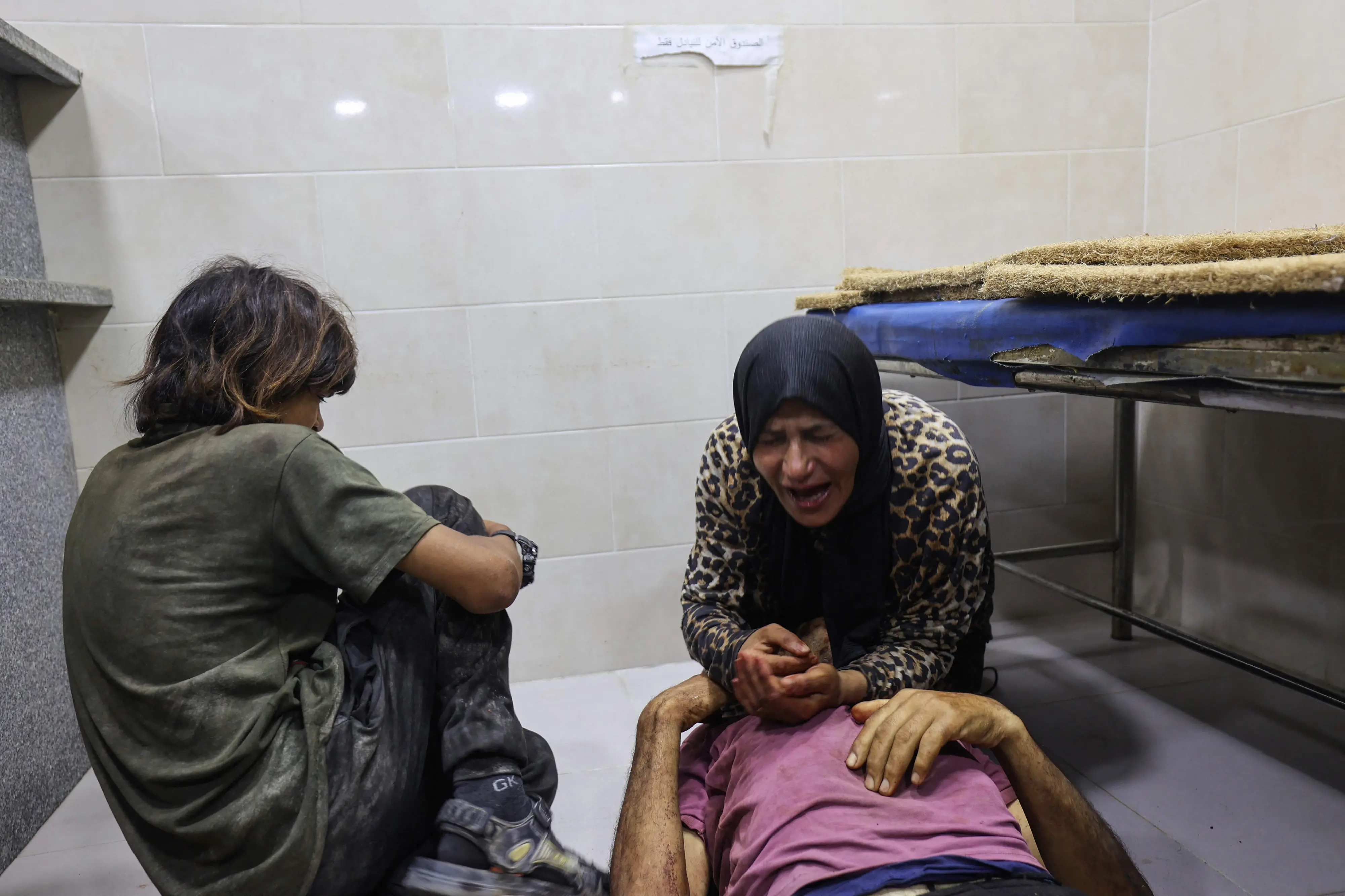 Palestinians mourn by the body of a man killed in Israeli fire at a food aid distribution point set up by the privately-run Gaza Humanitarian Foundation (GHF) on the Salaheddin road, at Al-Awda hospital in the Nuseirat refugee camp in the central Gaza Strip. | Photo: AFP