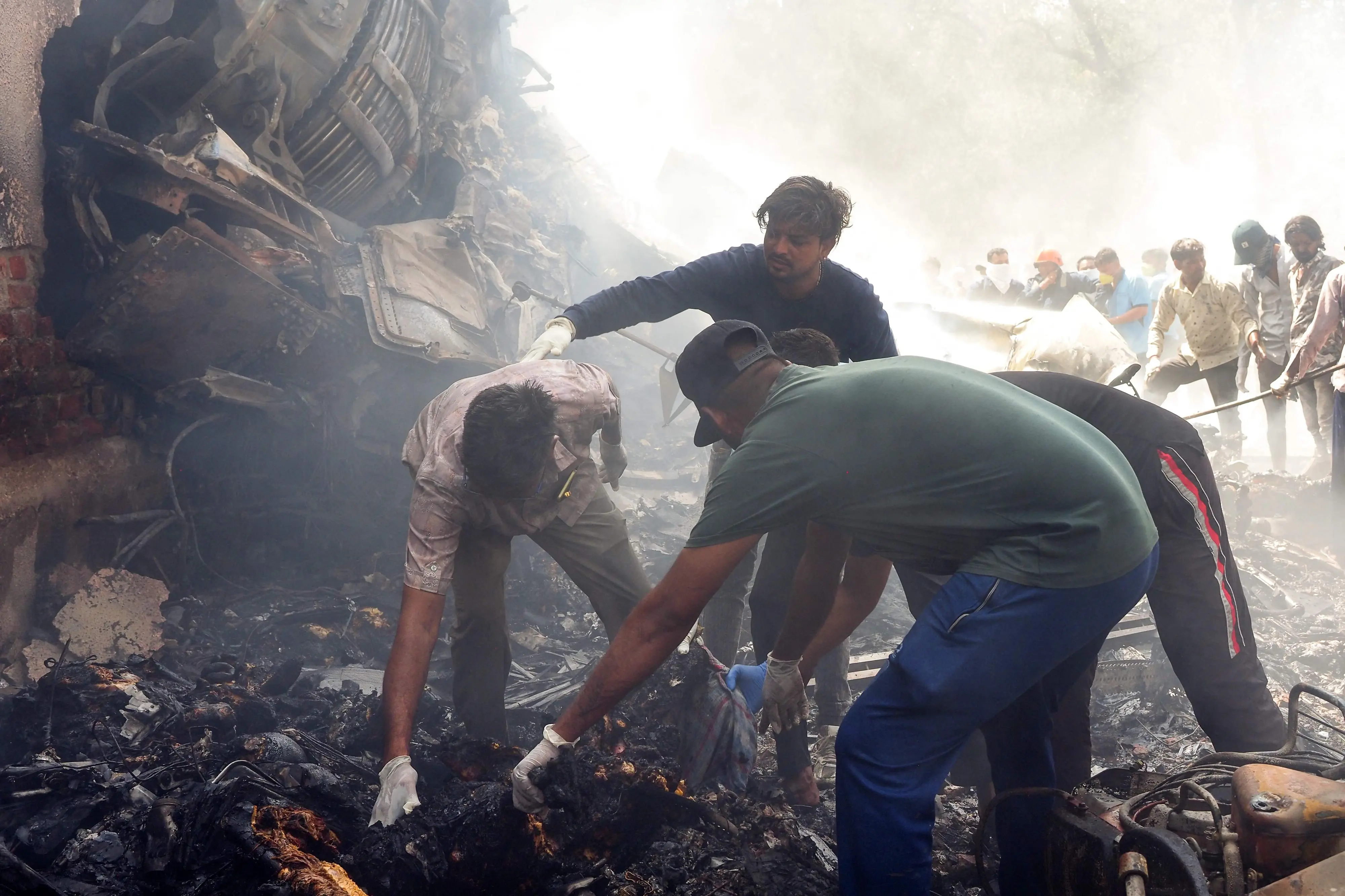 Rescue officials work at the site where Air India flight 171 crashed in a residential area near the airport in Ahmedabad.| Photo: AFP