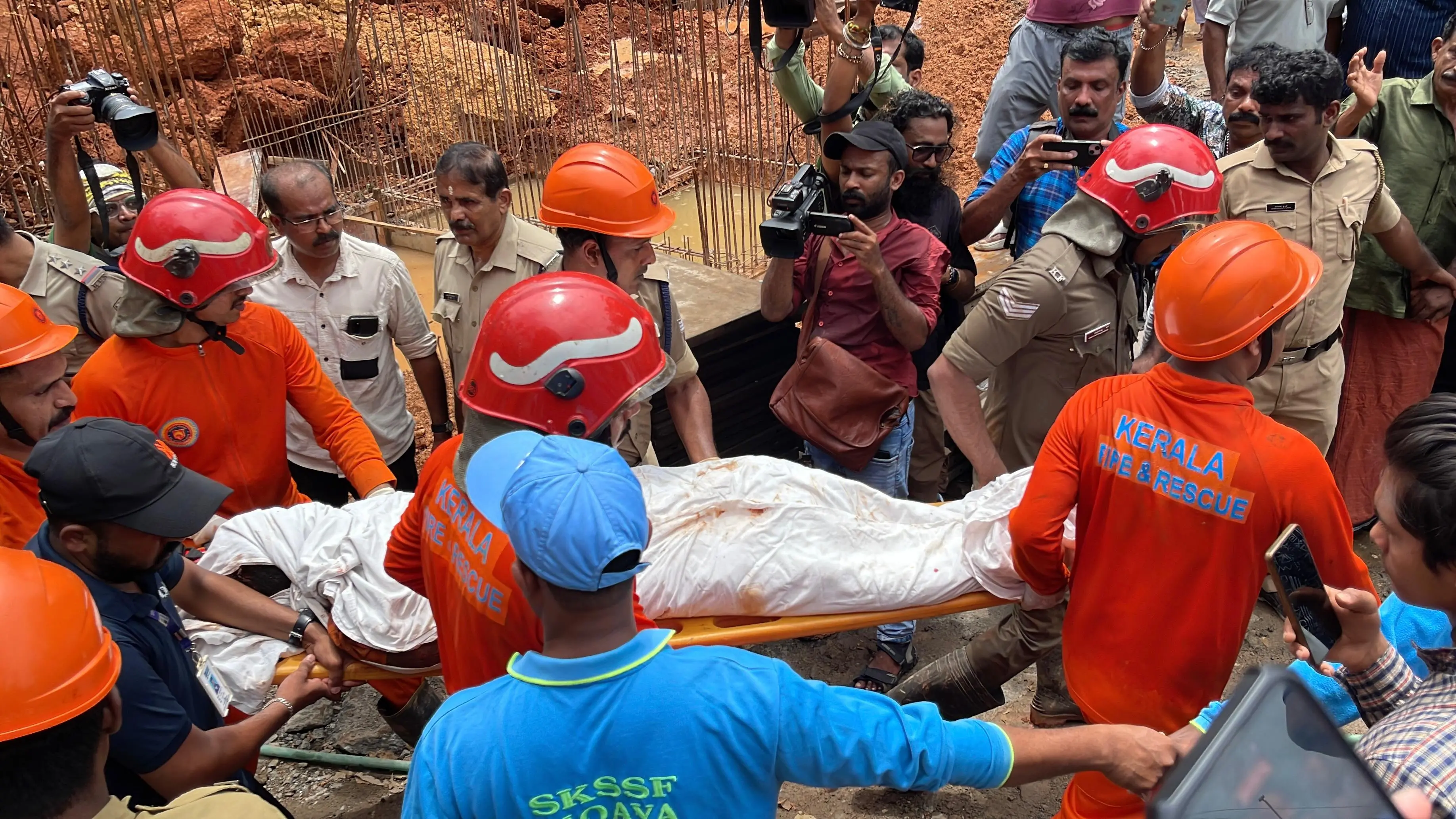 Fire and Rescue personnel carry the deceased on a stretcher from the scene
