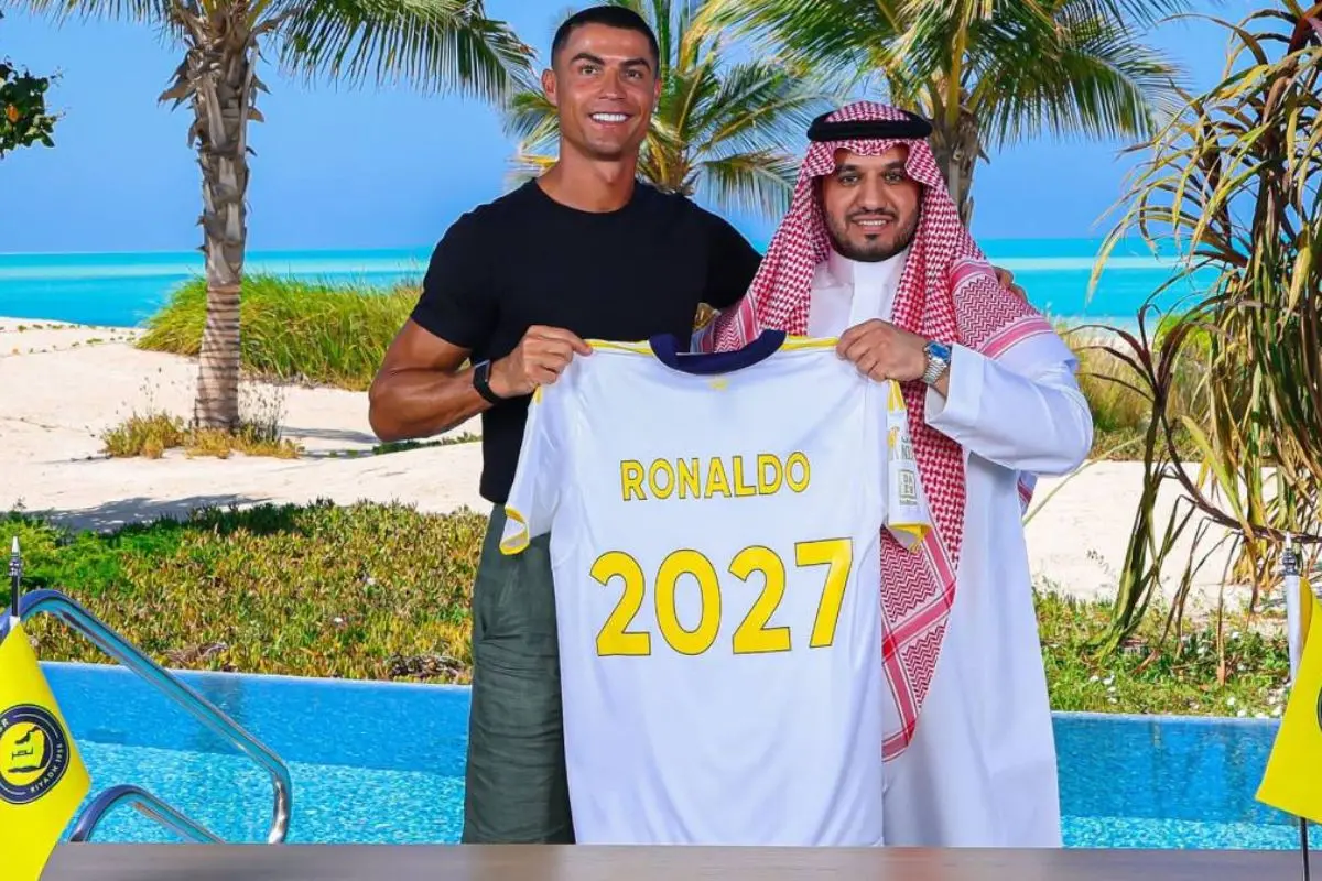 This handout picture released by Al-Nassr Football Club shows the Portuguese forward Cristiano Ronaldo (L) posing for a picture club chairman Abdullah Al-Majid after signing a new deal with the Saudi club at an undisclosed location. | Photo: AFP