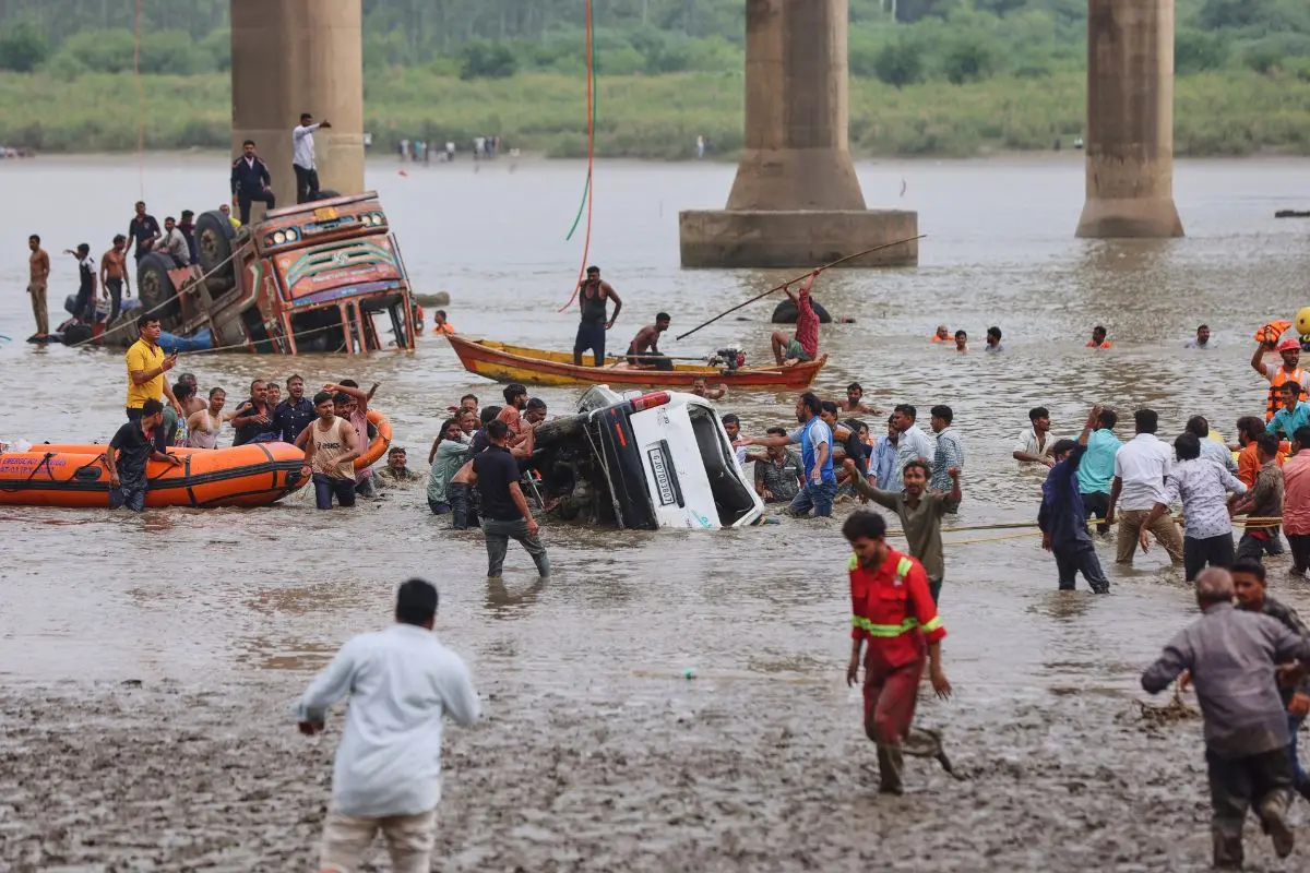 Rescuers and locals look for survivors after several vehicles fell into a river following the collapse of a portion of a bridge in Mujpur (Photo: AP/PTI)