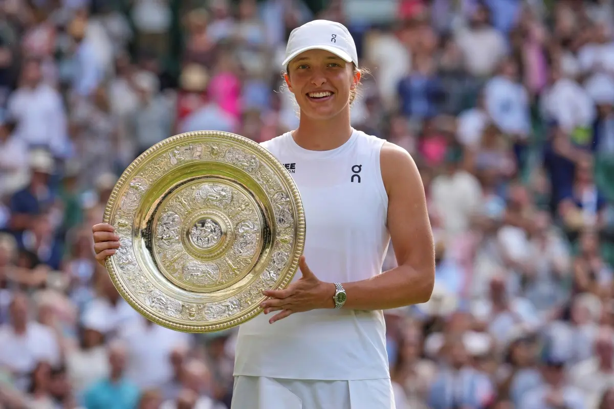 Poland's Iga Swiatek celebrates with the trophy after beating Amanda Anisimova of the U.S. to win the women's singles final at the Wimbledon Tennis Championships in London. | Photo: AP