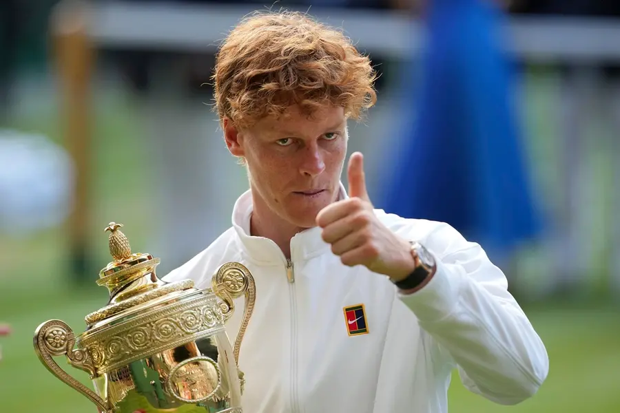 Italy's Jannik Sinner celebrates with the trophy after beating Carlos Alcaraz of Spain to win the men's singles final at the Wimbledon Tennis Championships in London