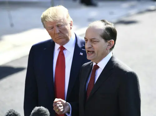 US President Donald Trump listens to US Labor Secretary Alexander Acosta as he speaks to the media at the White House in Washington, DC, after Acosta announced his resignation amid criticism of a secret plea deal he negotiated a decade ago with Jeffrey Epstein | File photo: AFP