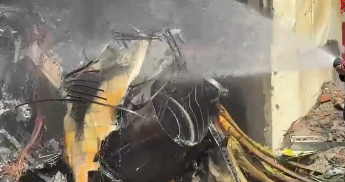 A fire service unit works to douse the flames as debris from the Bangladesh Air Force training jet is seen near the damaged school building | PTI Video