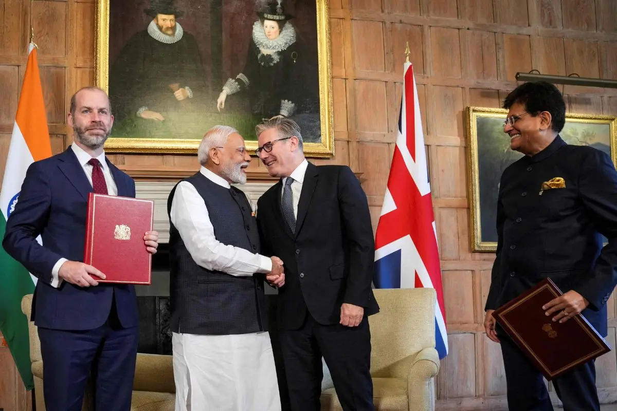 Prime Minister Narendra Modi and his British counterpart Keir Starmer (2nd R) shake hands next to Commerce Minister Piyush Goyal (R) and Britain's Business, Energy and Industrial Strategy secretary Jonathan Reynolds (L) holding the Free Trade Agreement newly signed during a meeting at Chequers in Aylesbury, England, on July 24, 2025.