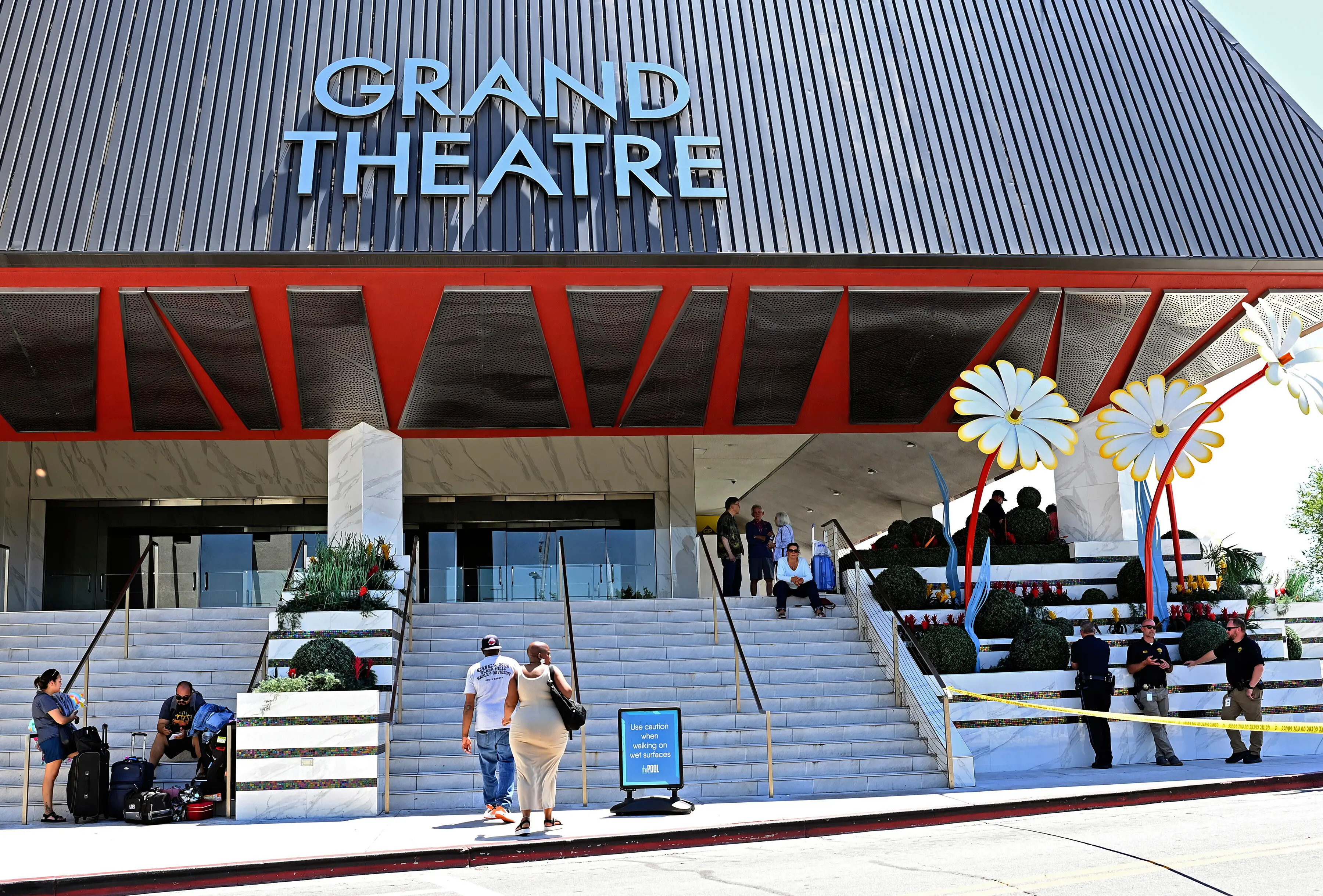 Police stand on the right of an entrance to the Grand Sierra Resort as guests arrive at the resort where a shooting occurred in Reno, Nevada | Photo: AP