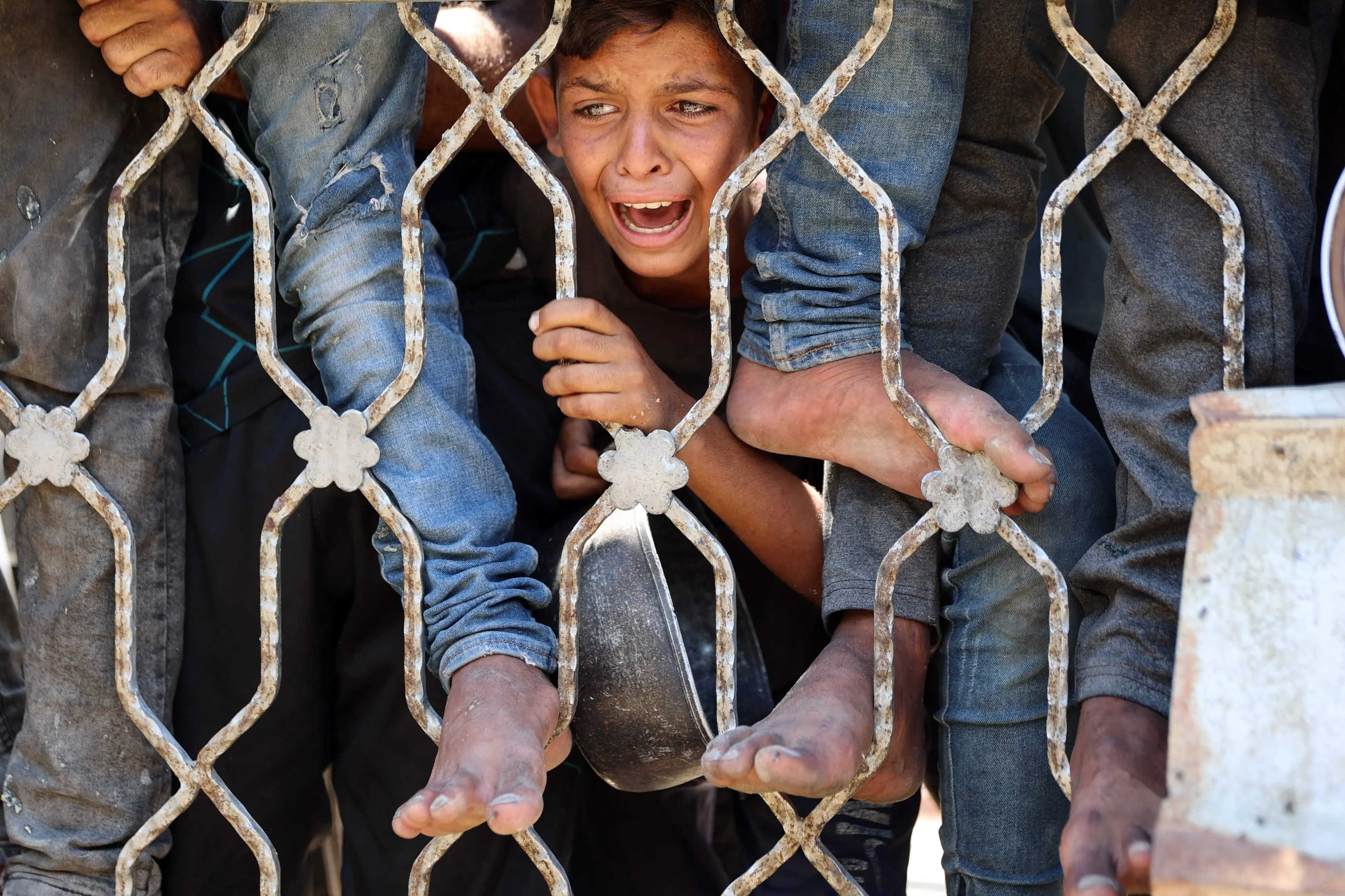 A Palestinians boy reacts while waiting at a lentil soup distribution point in Gaza City in the northern Gaza Strip. | Photo: AFP