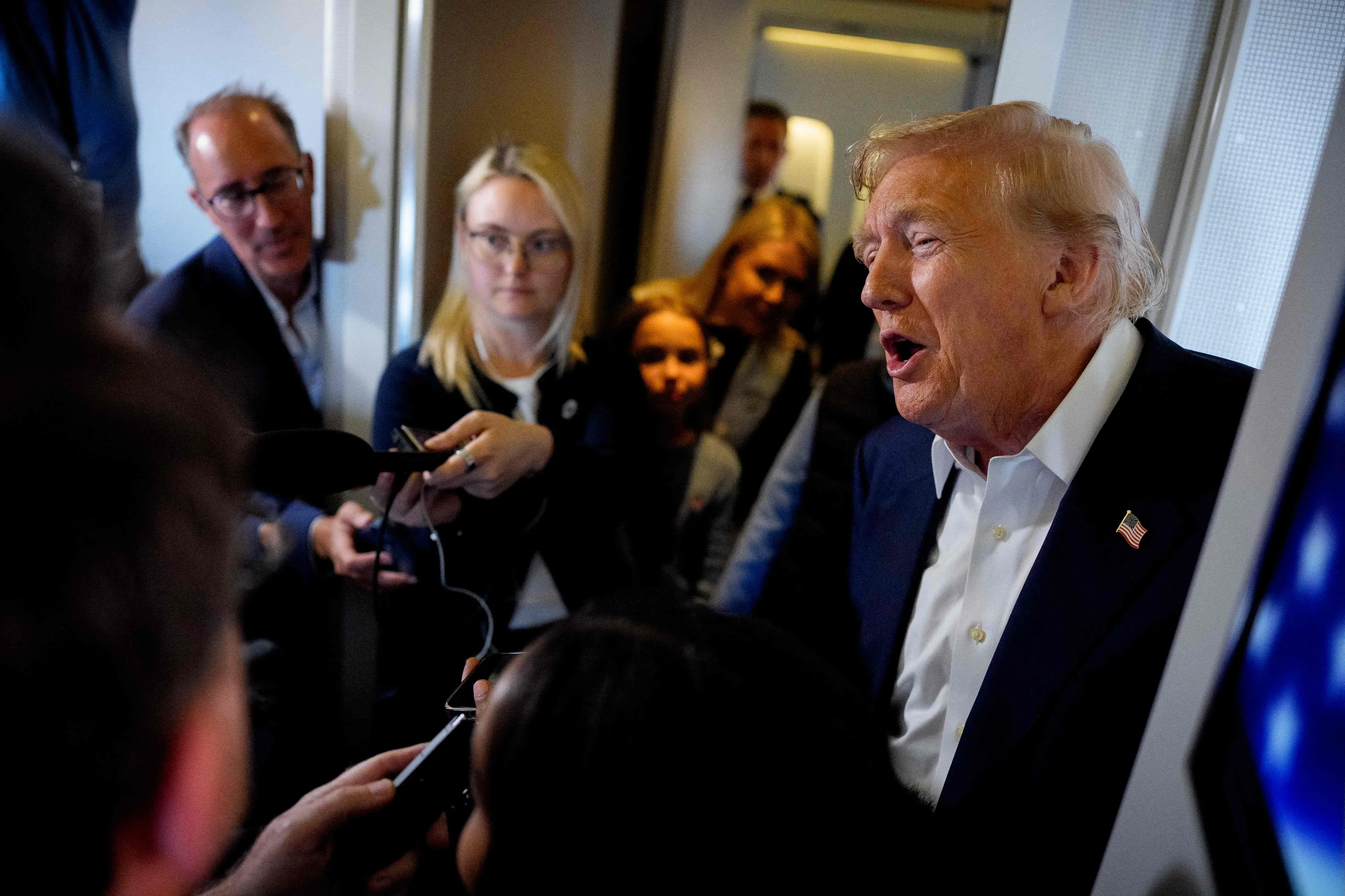 US President Donald Trump speaks to members of the media aboard Air Force One | Photo: AFP
