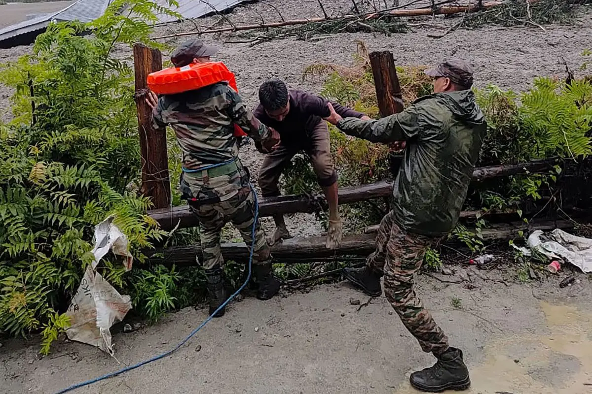 Indian Army shows security personnel rescuing a local resident (C) from dense sludge during a search and rescue operation after a cloudburst caused a massive mudslide in India's Uttarakhand state (Photo: AFP)