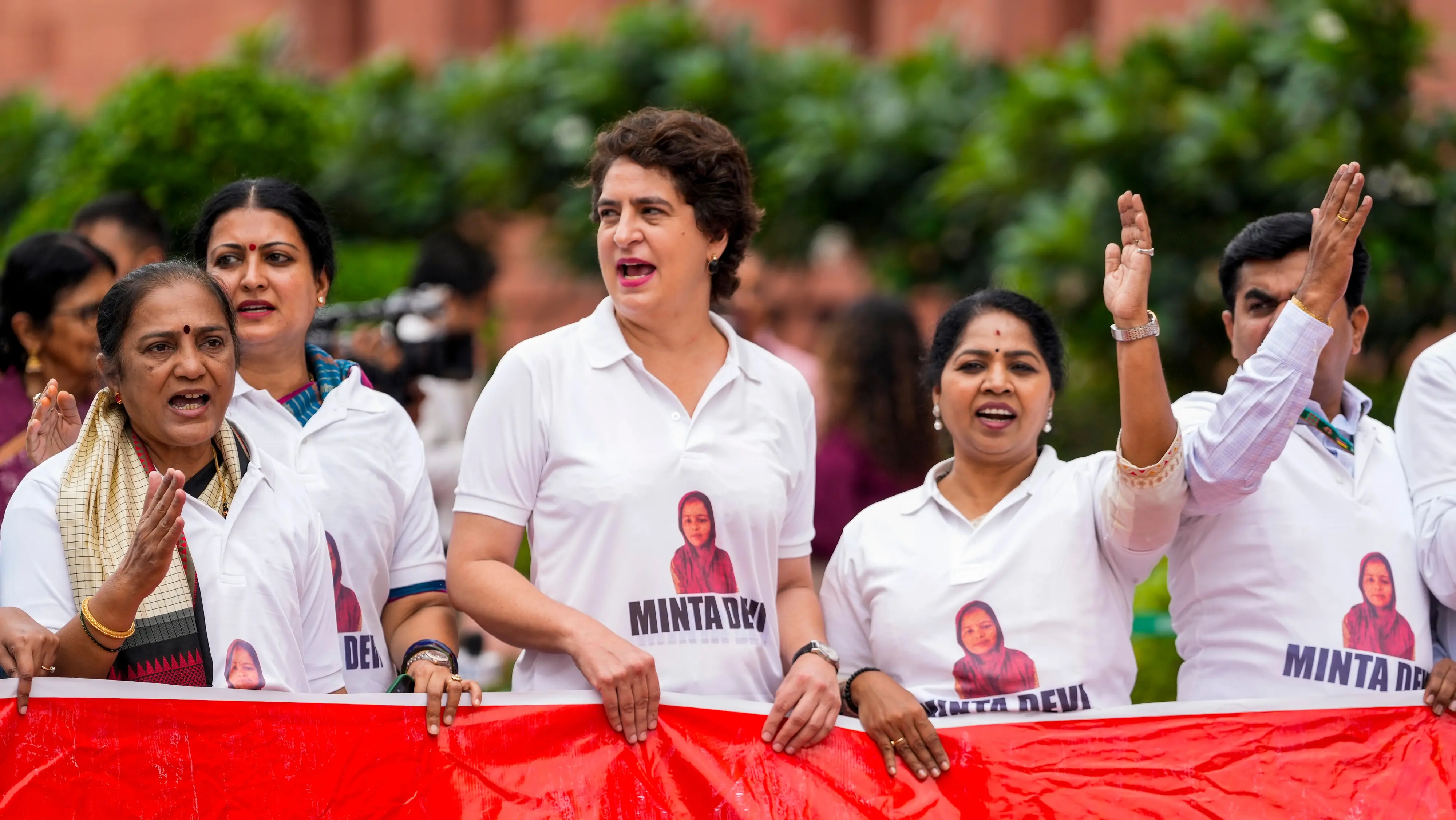 Congress MP Priyanka Gandhi Vadra and other INDIA bloc members seen wearing T-shirts featuring the name Minta Devi, a voter allegedly listed as 124 years old in the Election Commission's voter list during the protest at the Monsoon session of Parliament in New Delhi | Photo: PTI