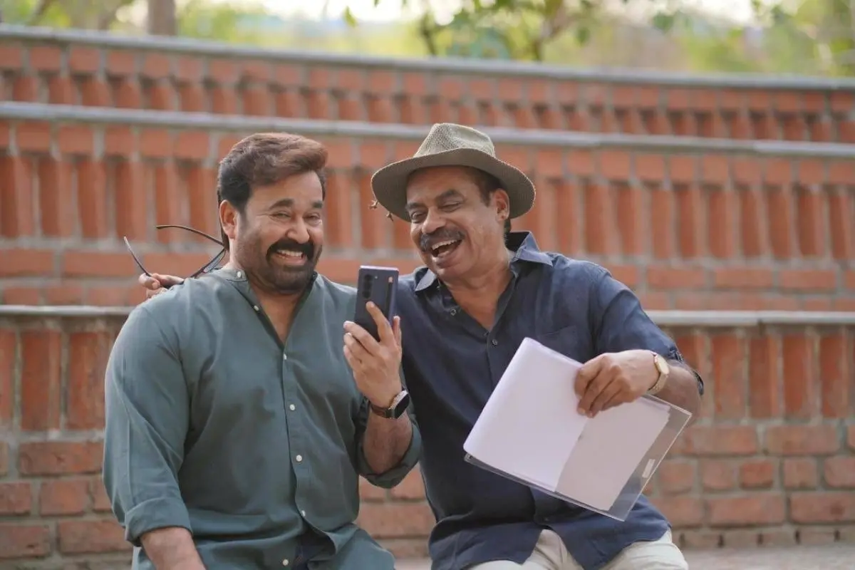 Sathyan Anthikad and Mohanlal share a lighter moment on 'Hridayapoorvam' movie set.