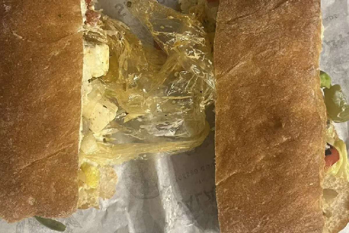 Viral photo shows the disposable glove discovered between the bread and fillings of the sandwich ordered via Zomato. Photo: X