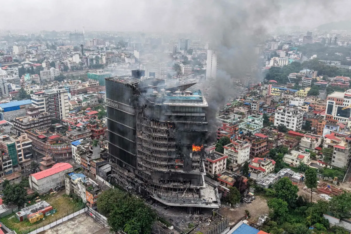 Smoke billows from the burning Hilton Hotels, a day after it was set ablaze by protesters in Kathmandu on September 10 | AFP