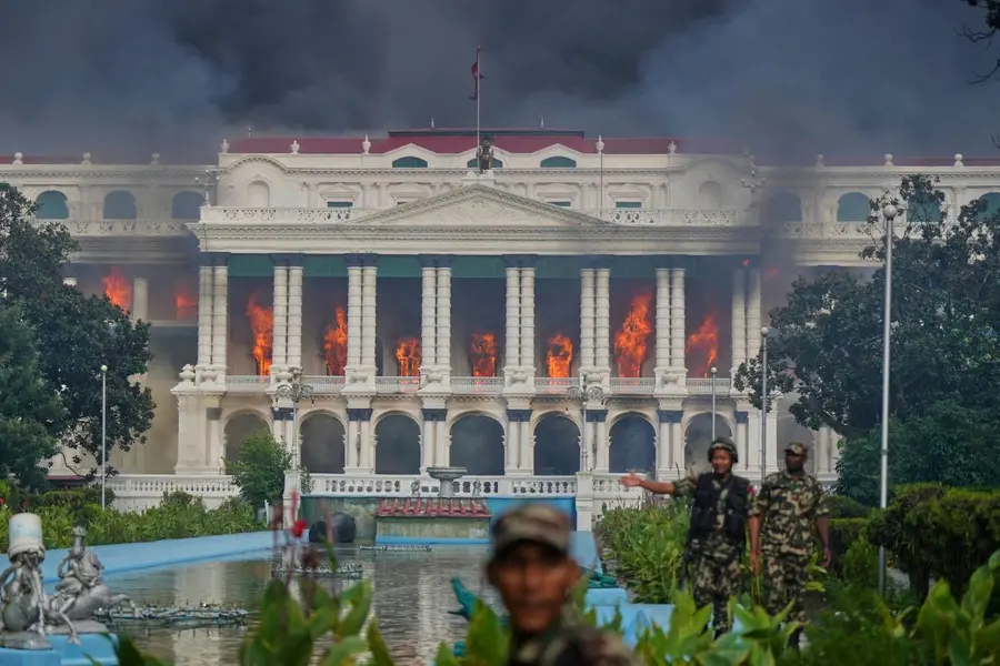 Nepalese army soldiers disperse protesters from Singha Durbar, the seat of Nepal's government's various ministries and offices, after it was set on fire during a protest against a social media ban and corruption in Kathmandu