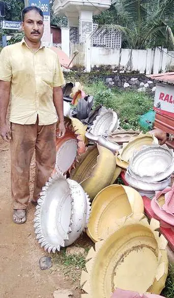 പഴയ ടയര്‍ ഉപയോഗിച്ച് നിര്‍മിച്ച പൂച്ചട്ടികള്‍ക്കരികില്‍ മനോജ് | ഫോട്ടോ: മാതൃഭൂമി