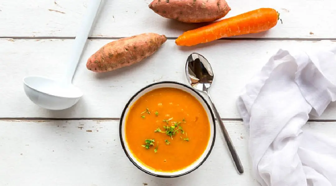 Bowl of sweet potato carrot soup garnished with cress - stock photo