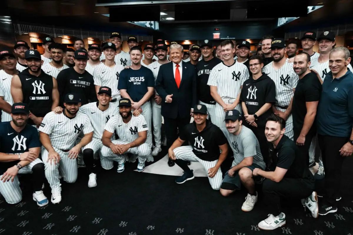 President Donald Trump poses with the Yankees players in the locker room ahead of their baseball game against the Detroit Tigers (Photo: AFP)
