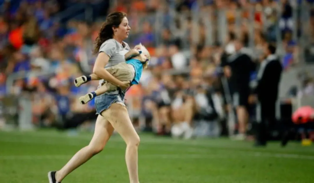 ഫുട്ബോള് ഗ്രൗണ്ടിലേക്കിറങ്ങിയ മകനേയും വാരിയെടുത്ത് ഓടുന്ന അമ്മ | Photo: twitter| Sam Greene