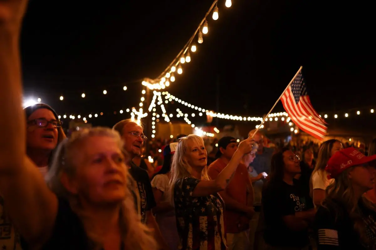 A woman waves a US flag during a candlelight vigil in memory of right-wing activist Charlie Kirk in Morristown, Arizona (Photo: AFP)