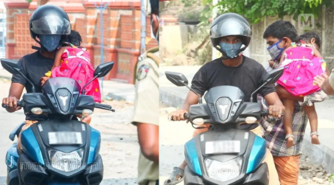 മകളേയും തോളിലേറ്റി ഒറ്റകൈയില് സ്കൂട്ടറോടിച്ചെത്തിയ യുവാവിനെ പോലീസ് തടയുന്നു. പിന്നീട് ബന്ധുവിനൊപ്പം പോകാന് അനുവദിച്ചപ്പോള് | ഫോട്ടോ: അഖില് ഇ.എസ്
