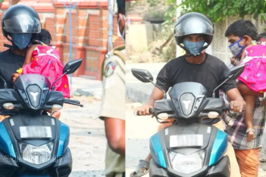 ഉറങ്ങുന്ന മകളേയും തോളിലേറ്റി ഒറ്റകൈകൊണ്ട് സ്കൂട്ടര് യാത്ര; തടഞ്ഞ് പോലീസ്, ശാസന