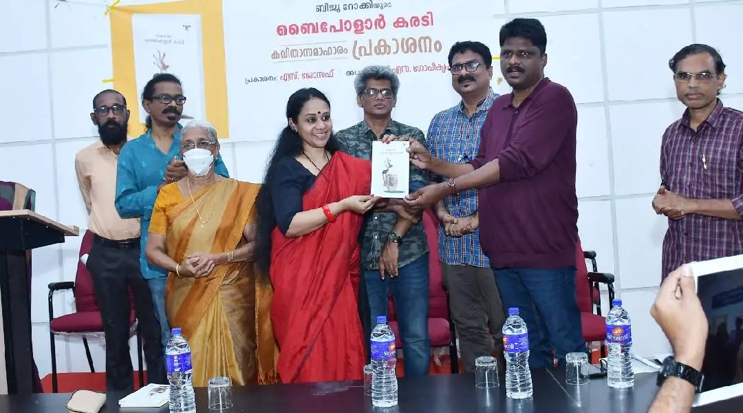 ബിജു റോക്കിയുടെ "ബൈപോളാർ കരടി" കവിതാ സമാഹാരം എസ് ജോസഫ്, സ്മിതാ ഗിരീഷിന് നൽകി പ്രകാശനം ചെയ്യുന്നു.