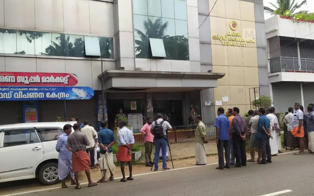 കണ്ടല സര്വീസ് സഹകരണ ബാങ്കിന്റെ തൂങ്ങാംപാറയിലെ പ്രധാന ഓഫീസില് ഇ.ഡി. പരിശോധന നടക്കുന്നതറിഞ്ഞ് പുറത്ത് നാട്ടുകാര് തടിച്ചുകൂടിയപ്പോള് | Photo: Mathrubhumi
