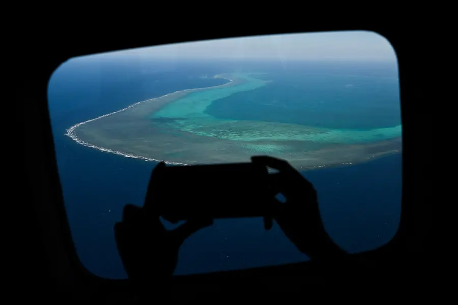 A reporter takes a video over the Scarborough Shoal in the disputed South China Sea | AFP