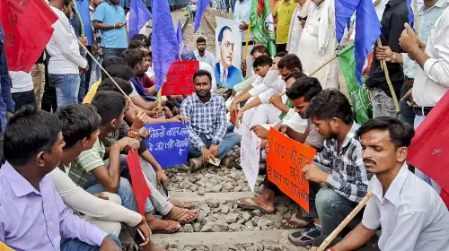 പ്രതിഷേധക്കാർ അറായിൽ റെയിൽവേ ട്രാക്കിൽ കുത്തിയിരുന്ന് പ്രതിഷേധിക്കുന്നു | Photo: PTI
