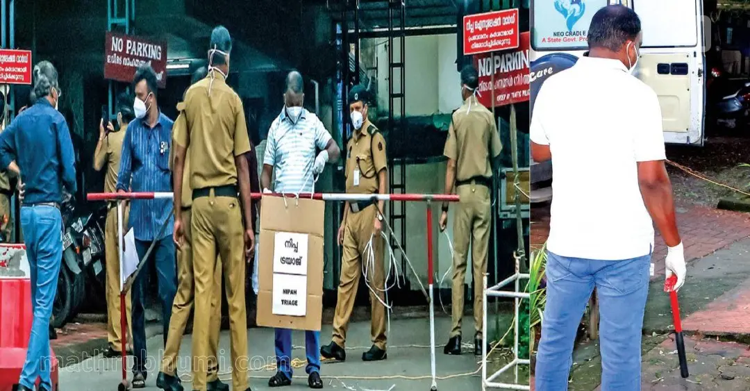 നിപ സ്ഥിരീകരിച്ചതോടെ കോഴിക്കോട് മെഡിക്കല്‍ കോളേജ് ഐസൊലേഷന്‍ വാര്‍ഡിലേക്കുള്ള പ്രവേശനം നിയന്ത്രിച്ചുകൊണ്ട് ബാരിക്കേഡും ബോര്‍ഡും വെക്കുന്നു (ഇടത്), ഐസൊലേഷന്‍ വാര്‍ഡിന്റെ താക്കോല്‍ കിട്ടാത്തതിനെ തുടര്‍ന്ന് ചുറ്റിക കൊണ്ട് അടിച്ചു പൂട്ട് പൊട്ടിച്ച ശേഷമാണ് വാര്‍ഡ് ഉപയോഗിക്കാവുന്ന രീതിയിലേക്ക് മാറ്റിയത്. പൂട്ട് പൊളിക്കാനായി ഉപയോഗിച്ച ചുറ്റികയുമായി നില്‍ക്കുന്നയാള്‍.