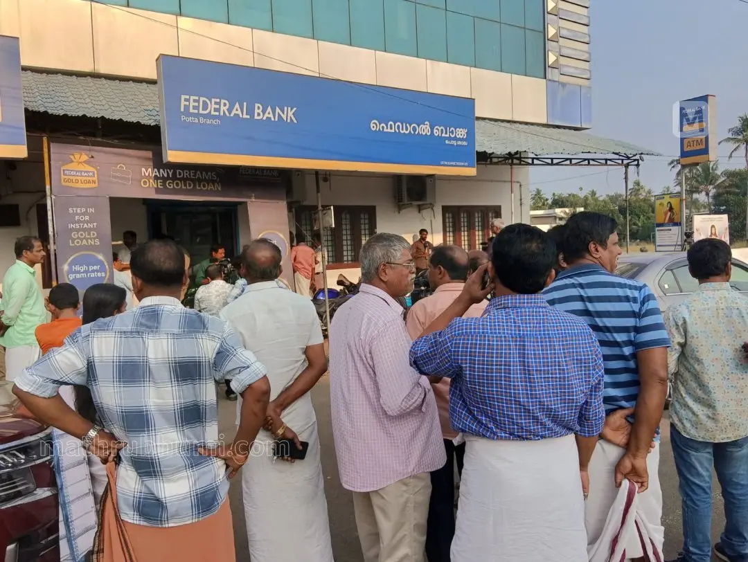 ചാലക്കുടി പോട്ട കവർച്ച നടന്ന ബാങ്കിന് മുന്നിൽ കൂടി നിൽക്കുന്ന ജനങ്ങൾ | ഫോട്ടോ: ജെ. ഫിലിപ്പ് / മാതൃഭൂമി