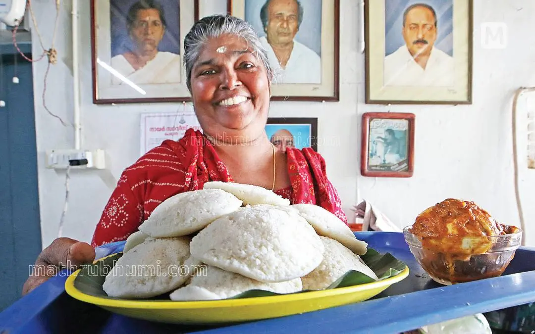 ചങ്ങനാശ്ശേരിയിൽ 105 വർഷമായുള്ള പിള്ളേച്ചന്റെ(ചെല്ലപ്പൻപിള്ള) ഇഡ്ഡലിക്കടയിൽ പ്രധാന വിഭവമായ ഇഡ്ഡലിയും മുട്ടറോസ്റ്റുമായി ഇപ്പോഴത്തെ നടത്തിപ്പുകാരി പിള്ളേച്ചന്റെ മരുമകൾ ശശികലാദേവി. പിന്നിലെ ഭിത്തിയിൽ, കട തുടങ്ങിയ പിള്ളേച്ചന്റെയും (നടുവിൽ) ഭാര്യയുടെയും മകൻ ഓമനക്കുട്ടന്റെയും ചിത്രങ്ങൾ |ഫോട്ടോ -ഇ.വി. രാഗേഷ്