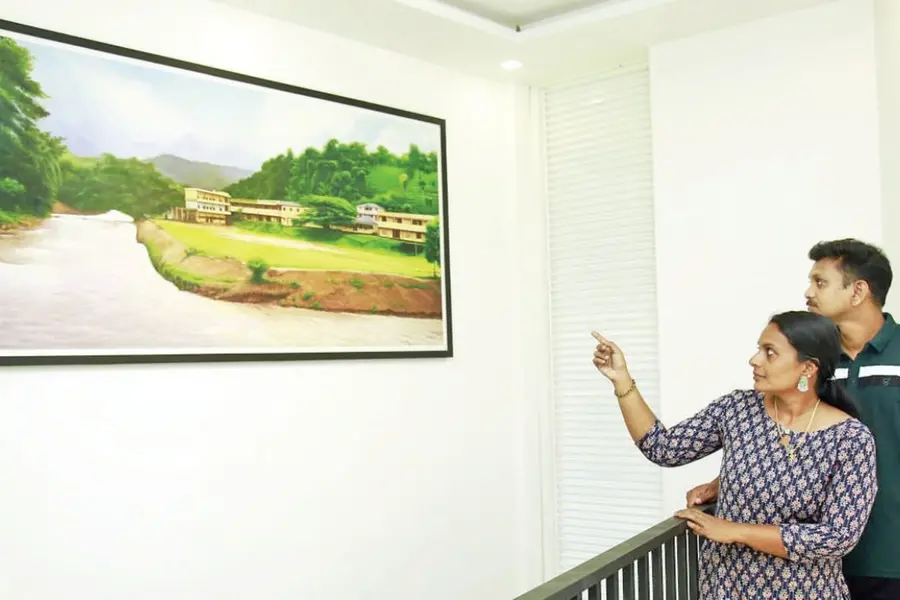 ഓർമ്മയിൽ വെള്ളാർമല; പുതിയ വീട്ടിൽ ഉരുൾപൊട്ടലിൽ തകർന്ന സ്കൂളിന്റെ മുൻകാല ചിത്രം സ്ഥാപിച്ച് അധ്യാപിക
