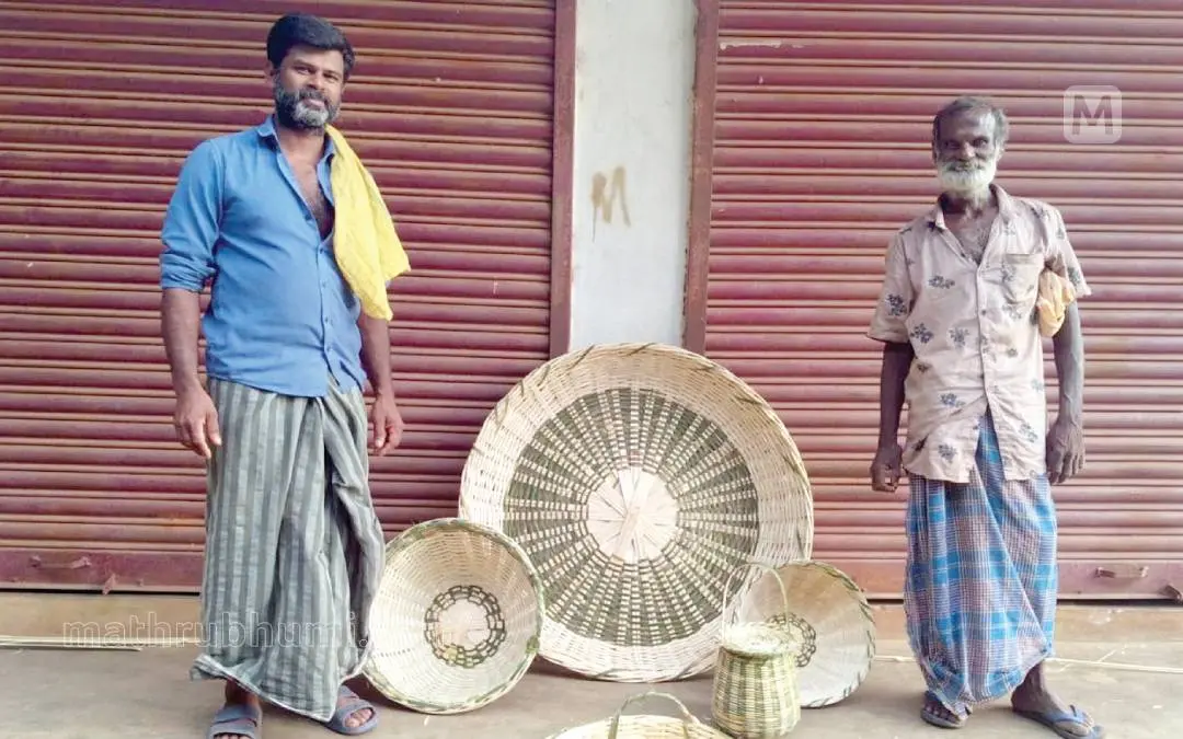 ആനക്കയം ഭാഗത്ത് കടത്തിണ്ണയിൽ നെയ്തുതീർത്ത ഈറ്റയുത്പന്ന അറുമുഖവും മകൻ ഭഗവതി രാജുവും | Photo: Mathrubhumi
