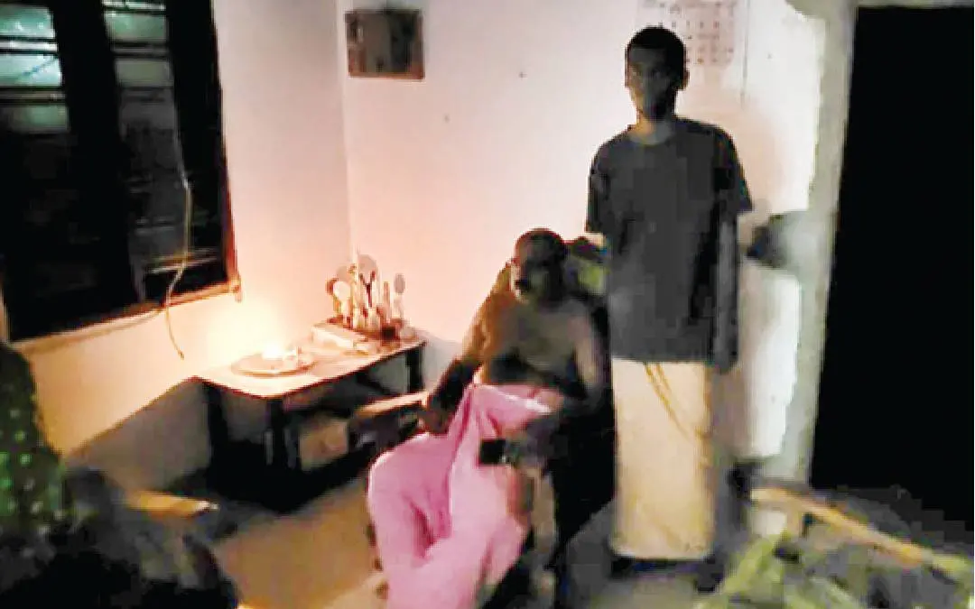 വൈദ്യുതിബന്ധം വിച്ഛേദിച്ചതിനെ തുടർന്ന് വലിയമടച്ചിറ വിനോദും മക്കളുംനിലവിളക്കിന്റെ വെളിച്ചത്തിൽ