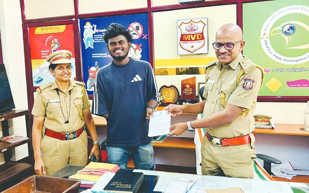 ഡ്രൈവിങ് ടെസ്റ്റിൽ ജയിച്ച കെവിന് ആർടിഒ കെ.ആർ. സുരേഷ് ഡ്രൈവിങ് ലൈസൻസ് കൈമാറുന്നു