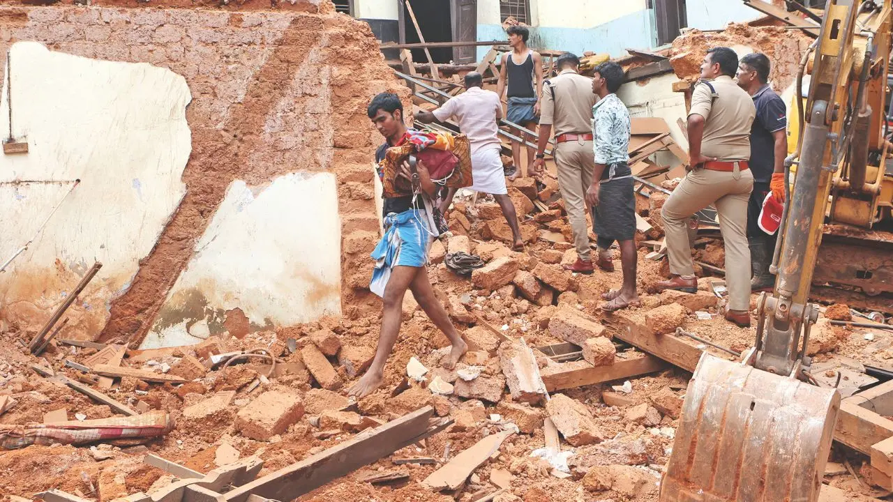 മൂന്ന് അതിഥിത്തൊഴിലാളികള് മരിച്ച സ്ഥലത്തെ അവശിഷ്ടങ്ങള്ക്കിടയിലൂടെ ബാക്കിയായ വസ്ത്രങ്ങളും സാധനങ്ങളും എടുത്തുനീങ്ങുന്നയാള്