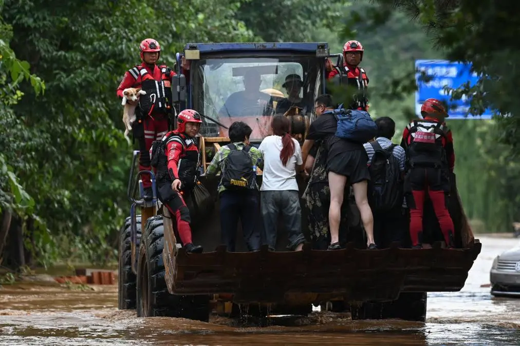 മിയുന് ജില്ലയിലെ തായ്ഷിതൂണില് വെള്ളപ്പൊക്കത്തില് നിന്ന് രക്ഷപ്പെടുത്തിയ ആളുകളെ വാഹനത്തില് കൊണ്ടുപോകുന്നു | Photo: AFP