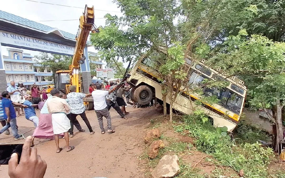 കുഴിയിലേക്കു വീണ സ്കൂൾവാൻ റോഡിലെത്തിക്കാനുള്ള ശ്രമം